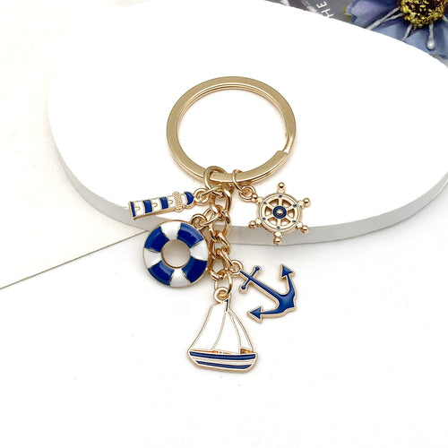 Alternate arrangement of the blue nautical lifebuoy anchor and sailboat keychain showing its hardware and charm details