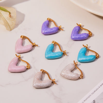On-ear view of enamel heart hoop earrings in main image 1.