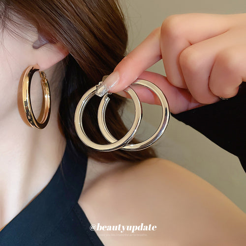 Smooth chunky silver-tone circular hoops arranged for a close front view.
