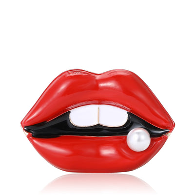 Red enamel lips brooch with white teeth and pearl on reflective white