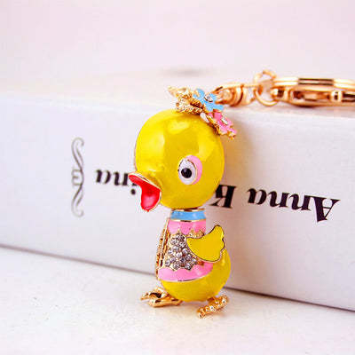 Close view of a yellow duck ornament with pink and blue details and clear stones.