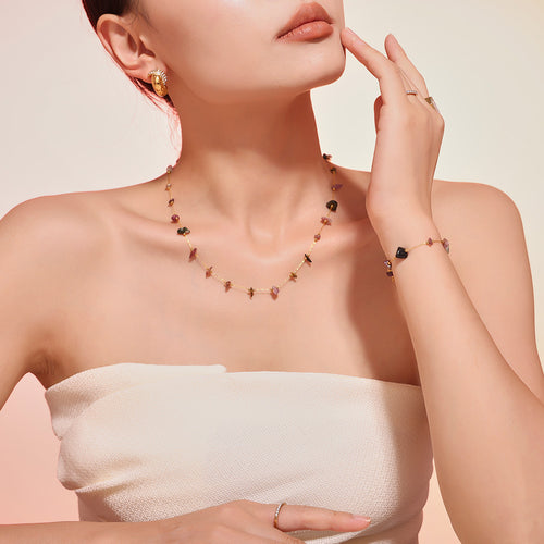 Multicolor chip stone necklace and bracelet on model in white top