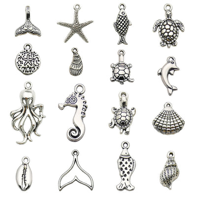 Antique silver seahorse and starfish charms arranged on a light background