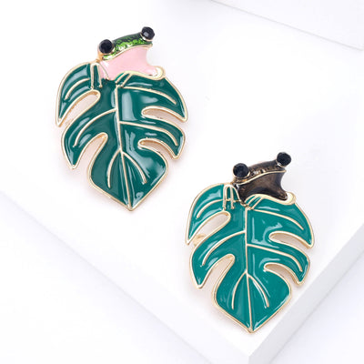 Small enamel frog perched across a striped tropical leaf brooch front view