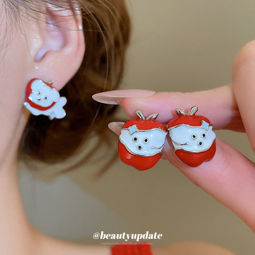 Styled view of red apple and white dog enamel character stud earrings