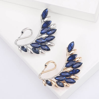 Silver Swan, Gold Swan brooch styles arranged on a light display