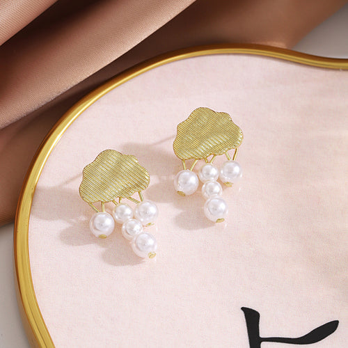 Gold cloud pearl raindrop earrings on pink tray with gold rim