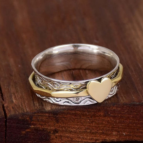 Side angle of dual-tone heart overlay ring showing silver inner band