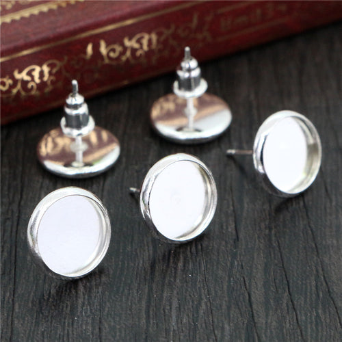 Closer grouped view showing the finish and shape of round bezel stud earring posts in mixed metal tones