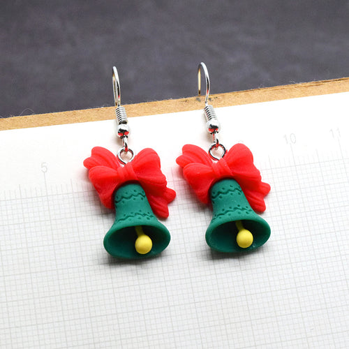 Pair of green resin Christmas bells with red bows close-up