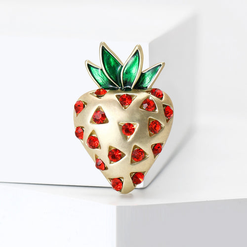 Angled display of heart-shaped strawberry dotted with red stones beneath green leaves