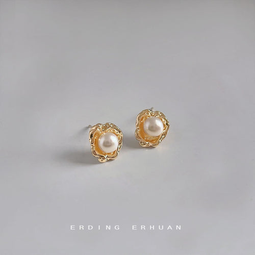 White pearl gold petal studs on grey surface
