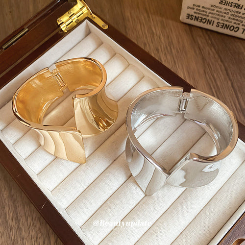 sculptural flared wide hinged cuff in gold-tone or silver-tone finishes shown worn in a styled second view