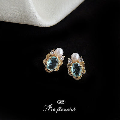 Gold-tone aqua-oval white-pearl clear-stone studs in the first product display.