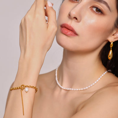 Model wearing gold cable chain freshwater pearl toggle bracelet