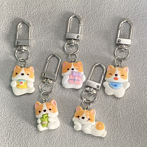 Same five corgi pose keychains arranged on gray background