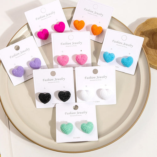 Assorted beaded heart stud earrings multicolor on cards on ceramic plate