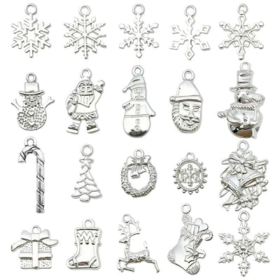 Silver-tone christmas tree and bell charms arranged on a light background