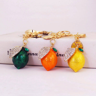 Three textured lemon keychains in green, orange, and yellow displayed together.