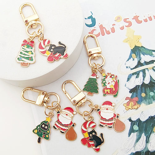 Four Christmas gold clasp keychains with cats trees Santa on Christmas paper