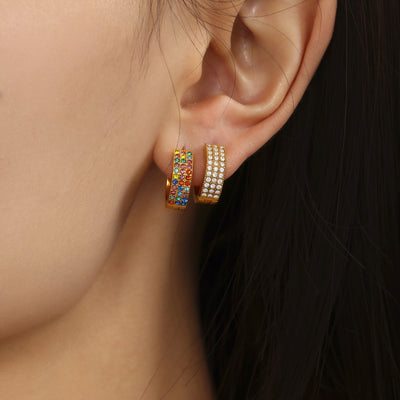 Ear wearing gold multicolor and gold clear pave huggie hoops stacked
