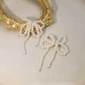 Four White Pearl Look Bow Long Dangle Stud Earrings view 3