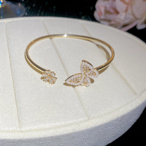 Gold open cuff with pearl crystal butterfly and crystal flower tip
