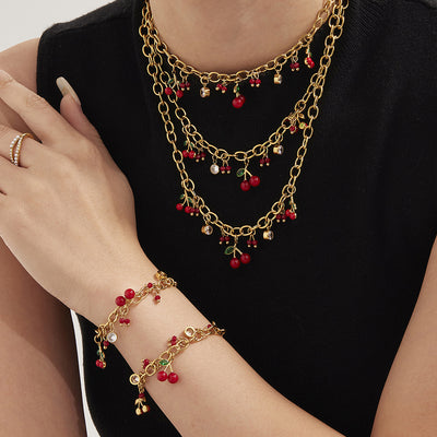 Coordinated set view of red cherry crystal necklace and bracelet in main image 1.
