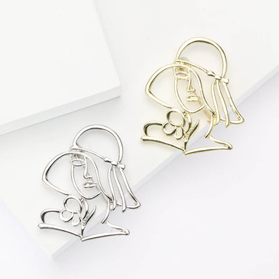 Gold Portrait, Silver Portrait brooch styles arranged on a light display