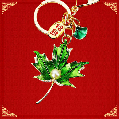 Main image 1 shows a supplied presentation of enamel maple leaf keychains with visible attached key hardware.
