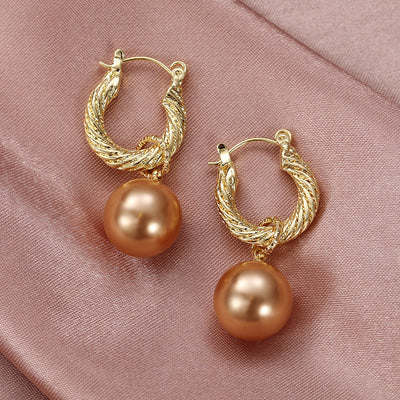 Gold twisted hoop champagne pearl drop earrings on pink satin