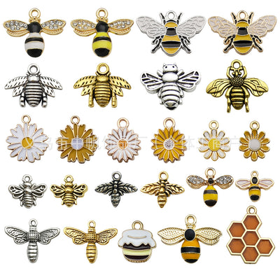 Colorful bee and daisy charms arranged on a light background
