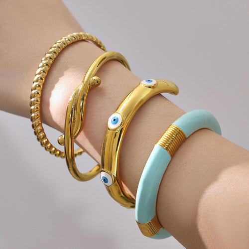 On-wrist view of bamboo and geometric bangle collection in main image 2.