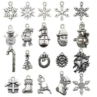 Antique silver christmas tree and snowflake charms arranged on a light background