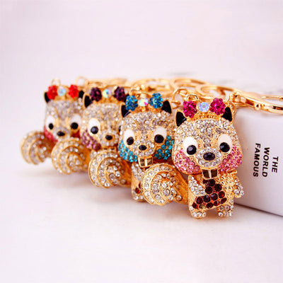 Four gold-tone squirrel keychains lined up with red, purple, blue, and pink rhinestone accents.