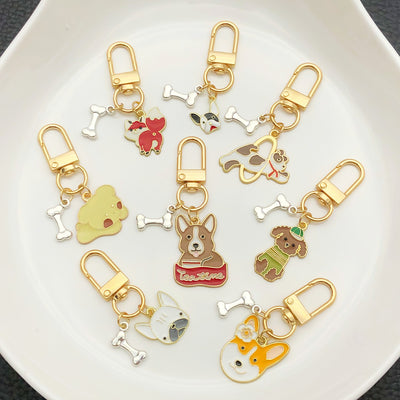 Front display of sixteen jumping and playful dog clasp keychains with visible colors and attached hardware