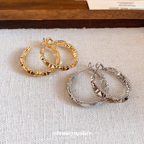 Faceted Metal Hoop Earrings in Gold and Silver Tones arranged flat to show the full design