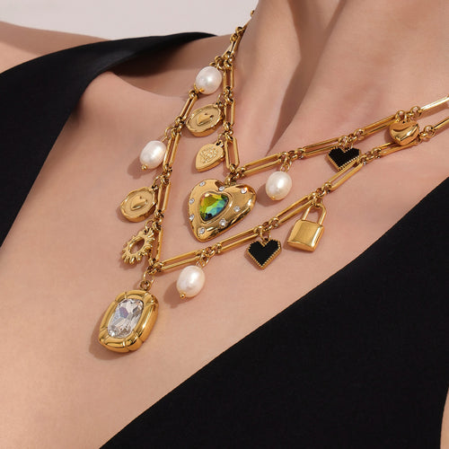 Model layering gold multi-charm necklaces with heart and zircon pendants