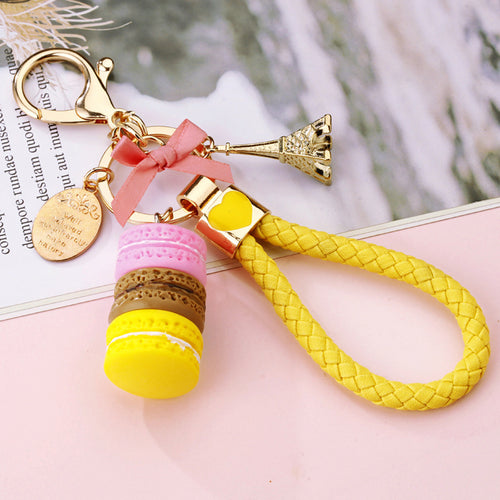 A second supplied view shows another pictured color or design of the stacked macaron keychain.