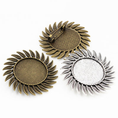 Round cabochon brooch tray framed by radiating leaf shapes in a group view on a white background