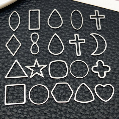 Black cross and heart charms arranged on a light background