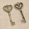 Long Heart Bow Key Charm in an Antique Bronze Finish view 3