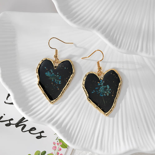 Pair of irregular black heart earrings with red pressed flowers and gold-tone hooks