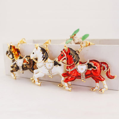 Three prancing horse pendants in red, white, and brown with clear stone detailing.