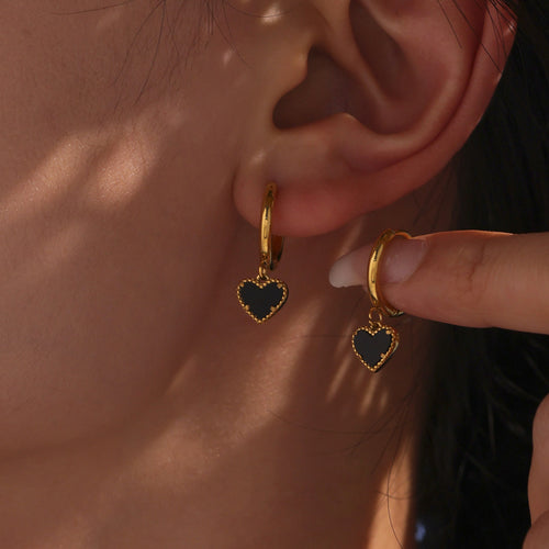 Gold black agate heart hoop earrings worn and held
