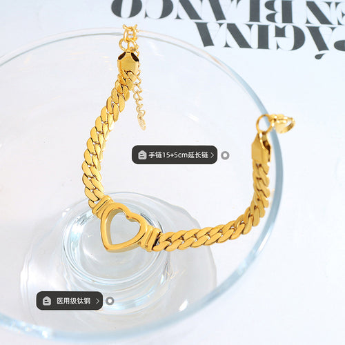 Gold heart curb bracelet on glass with length and titanium labels