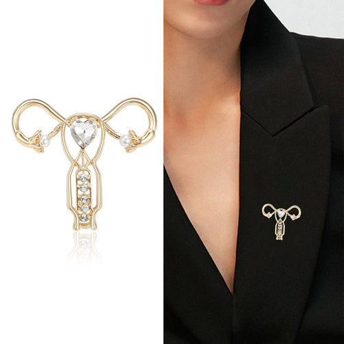 Gold uterus brooch product and worn on black blazer lapel