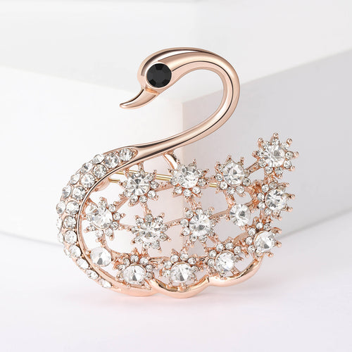 Rose gold openwork swan brooch with black eye close-up