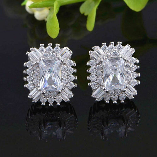 Angled detail of silver tone emerald cut crystal cluster stud earrings
