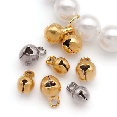 Metallic bell charms arranged on a light background